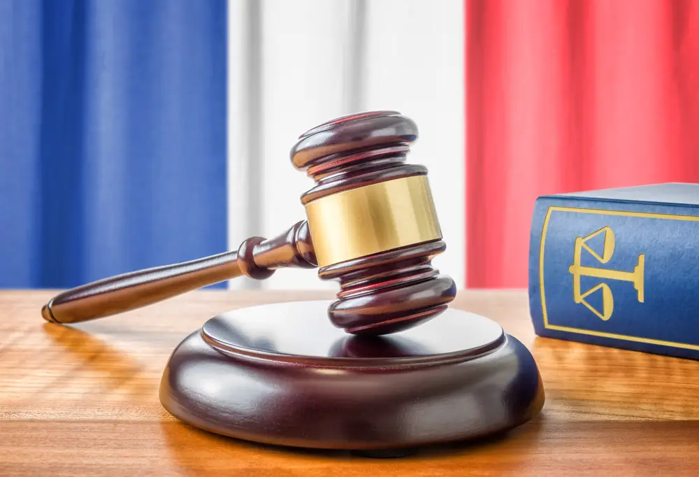 La statue de la justice Thémis ou Justitia, la déesse de la justice aux yeux bandés contre le drapeau de la France, comme concept juridique