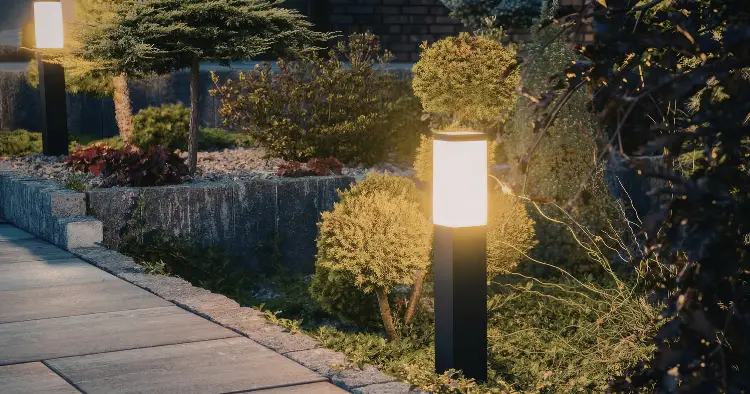 Allée de jardin éclairée de nuit par des bornes lumineuses